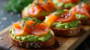 Bruschetta saumon avocat garnies d'aneth frais et de baies roses, disposées sur une planche en bois rustique